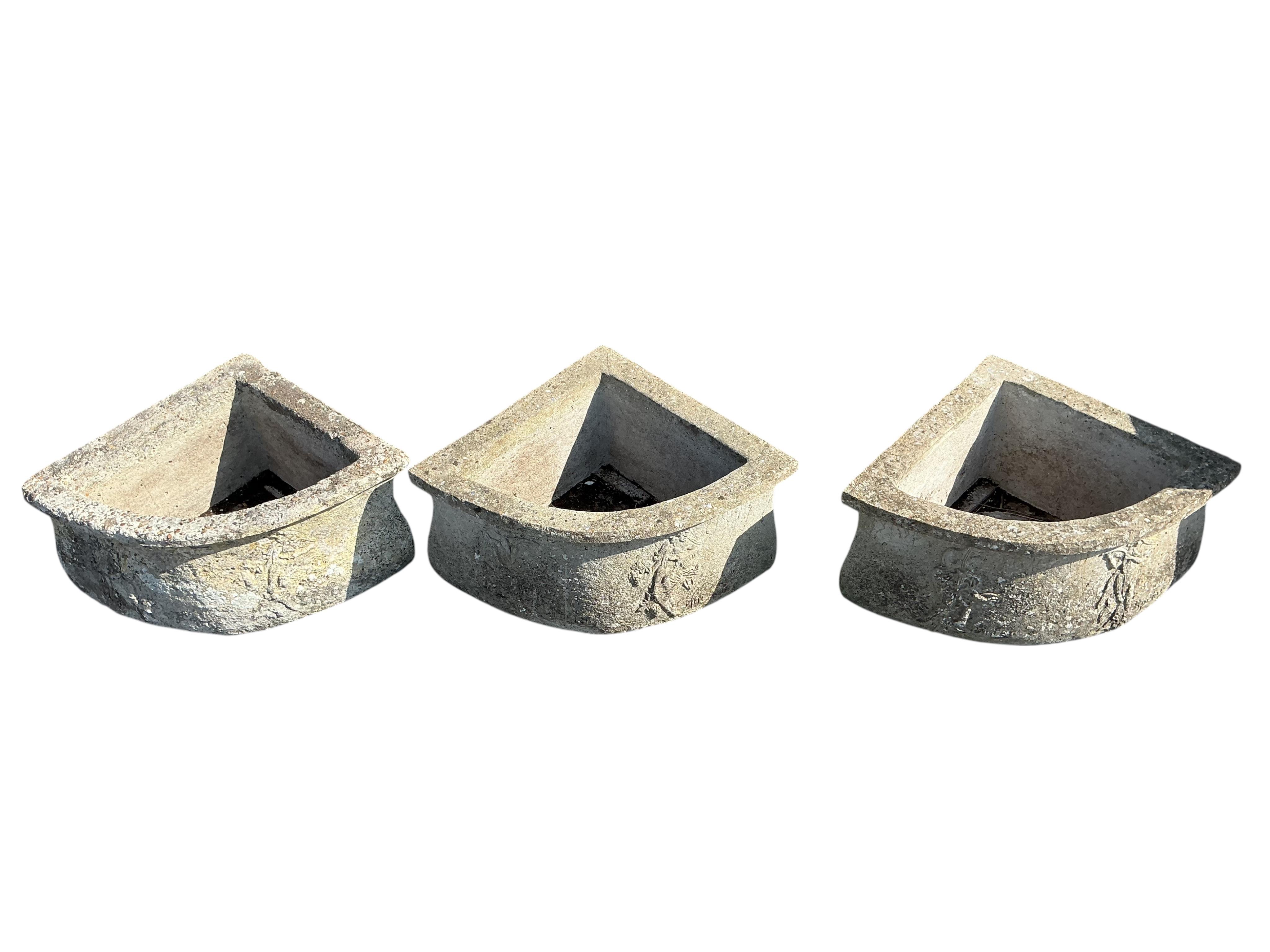 A set of three triangular reconstituted stone garden planters, width 60cm, depth 45cm, height 25cm